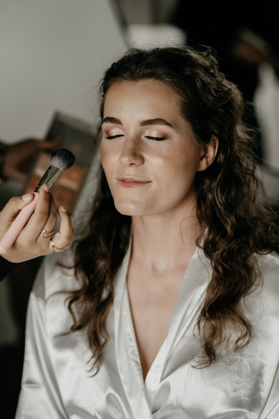 een afbeelding van een vrouw die haar make-up laat doen