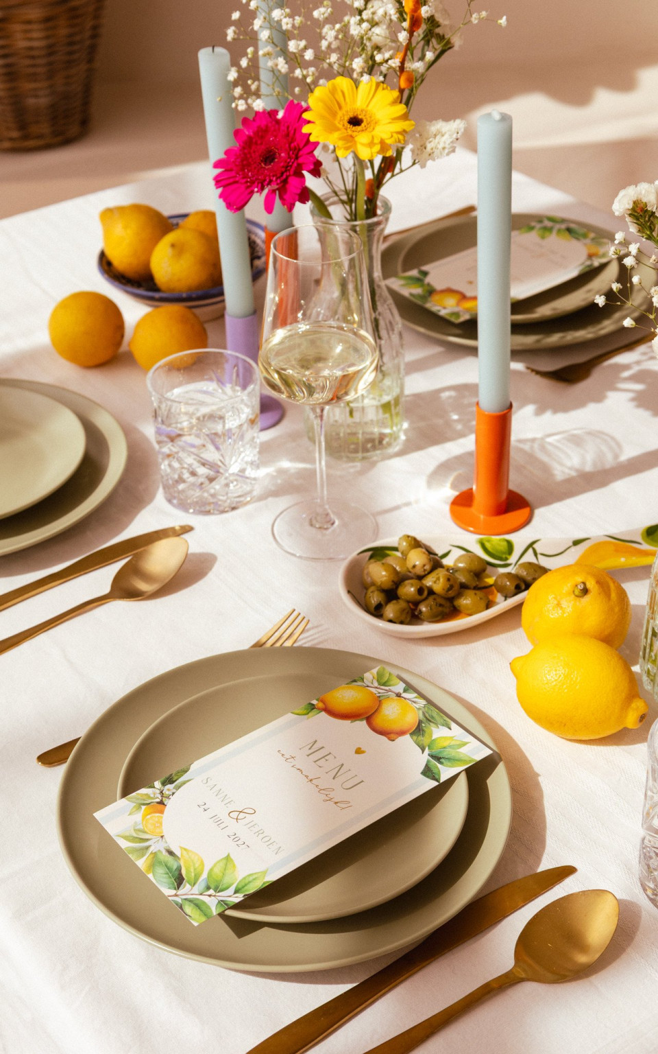 een tafel gedekt met borden, bestek en bloemen