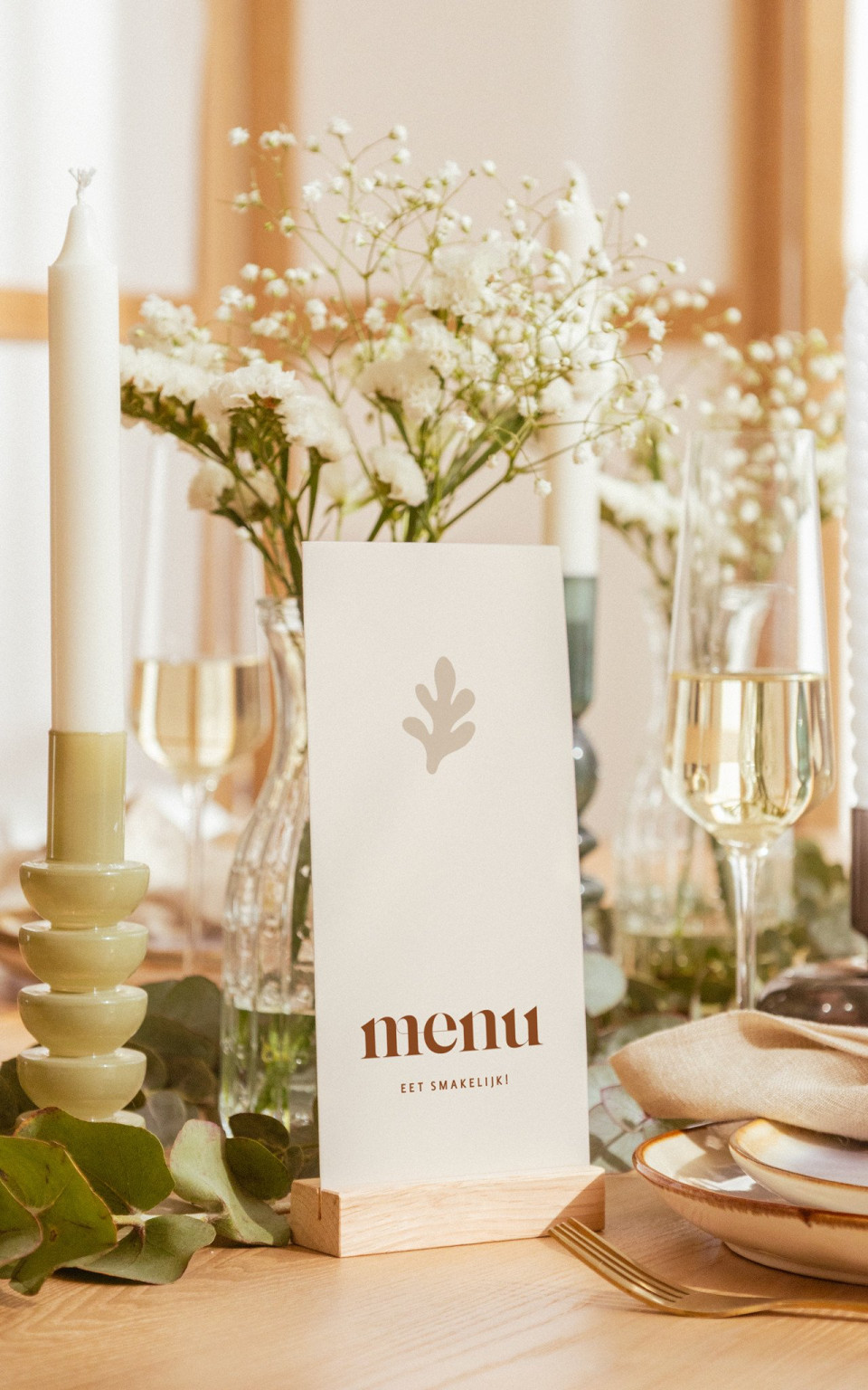 een tafelsetting met een menu en wijnglazen