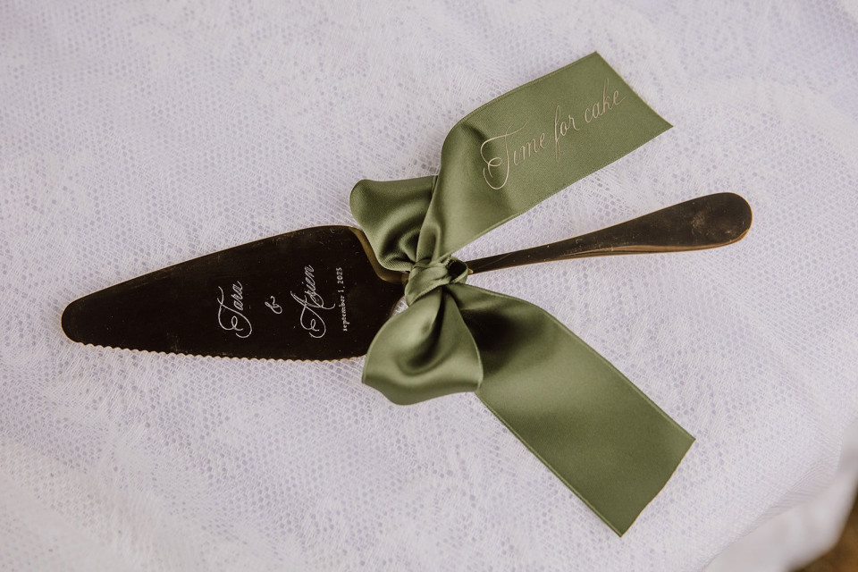 een afbeelding van een bruidstaartmes met een strik eraan