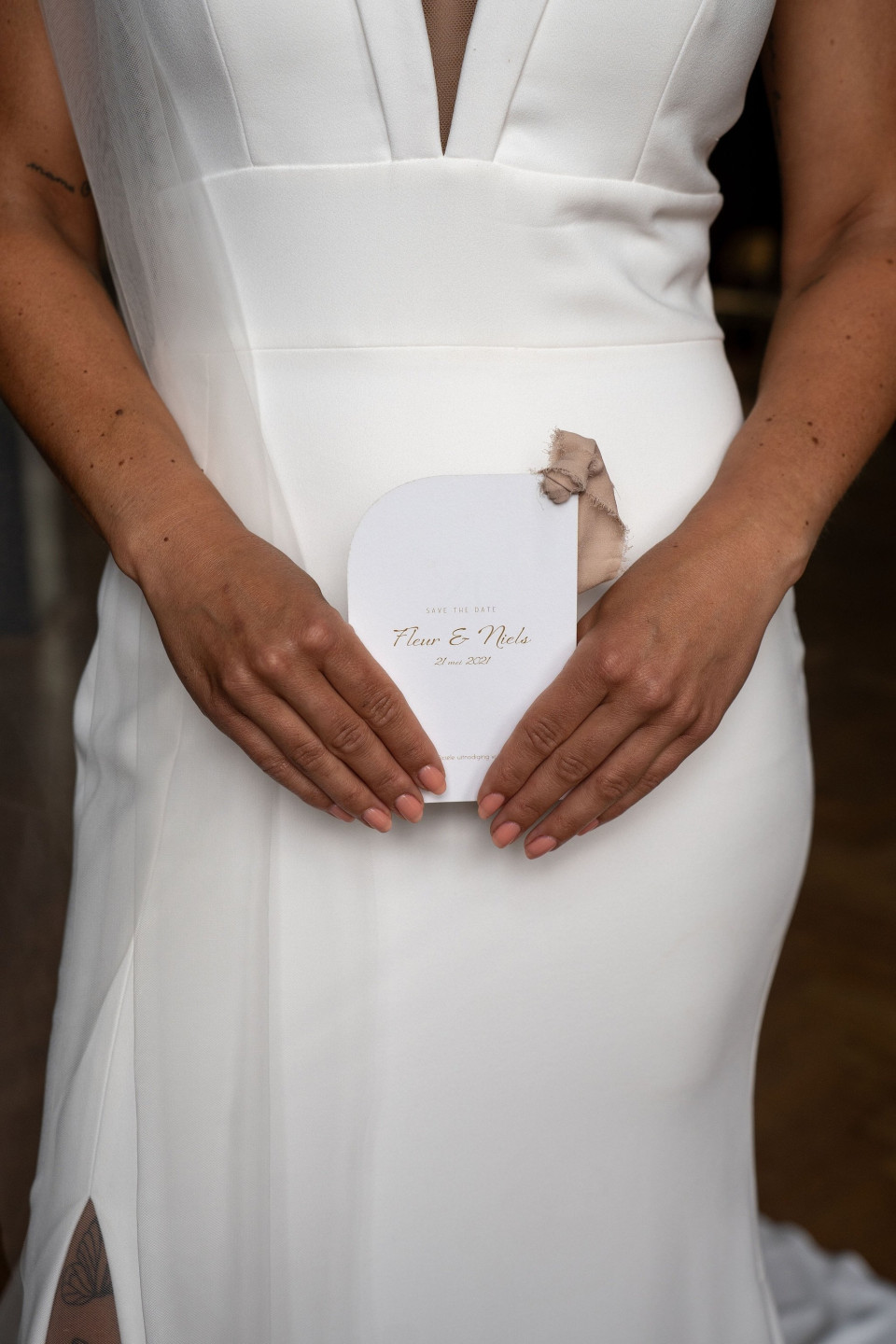 een vrouw in een witte jurk die een witte kaart vasthoudt