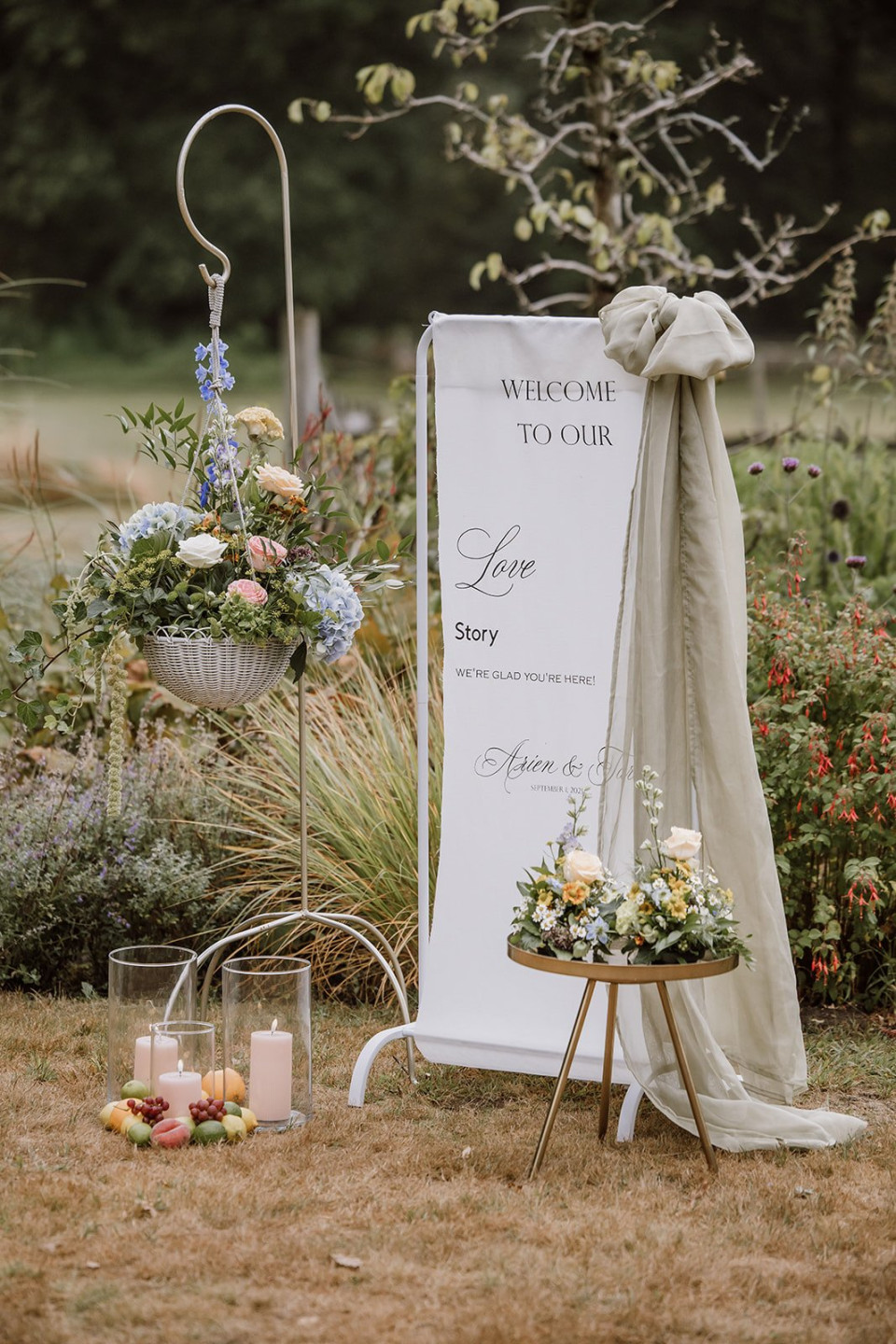 een bord dat zegt: welkom in ons liefdesverhaal naast bloemen en kaarsen