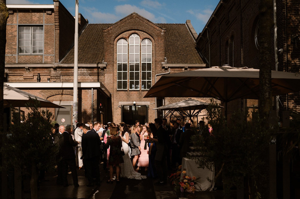 een grote groep mensen die voor een gebouw staan