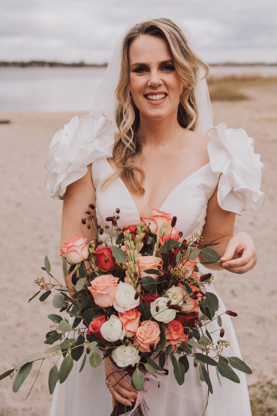 een vrouw in een trouwjurk die een boeket bloemen vasthoudt