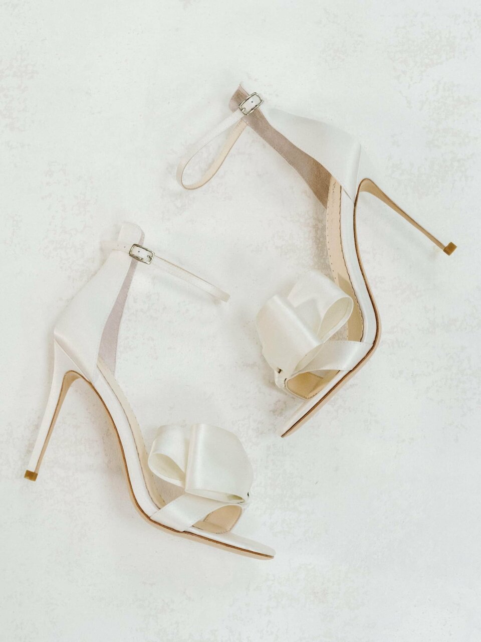 een paar witte hoge hakken met strikken erop