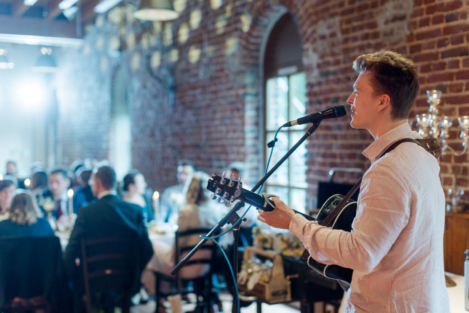een man die gitaar speelt in een restaurant