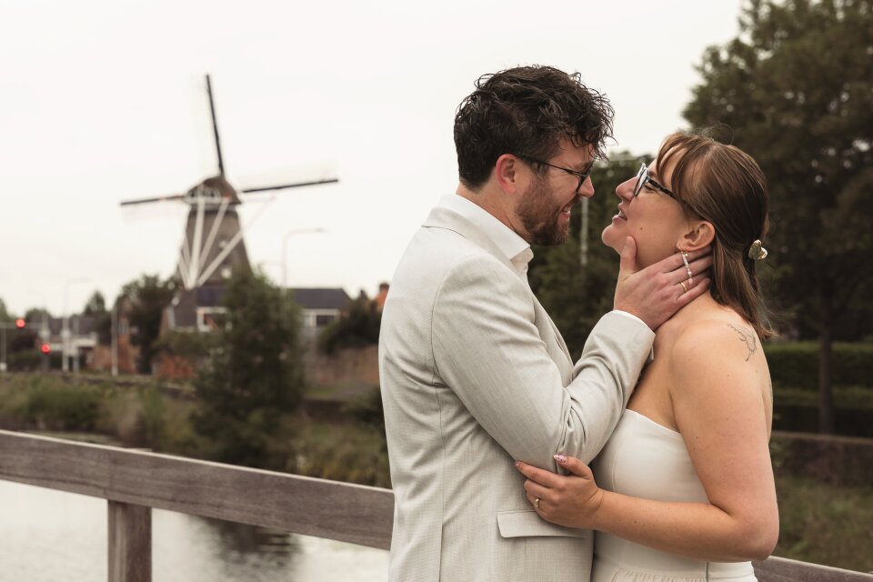 een man en een vrouw staan naast elkaar voor een windmolen