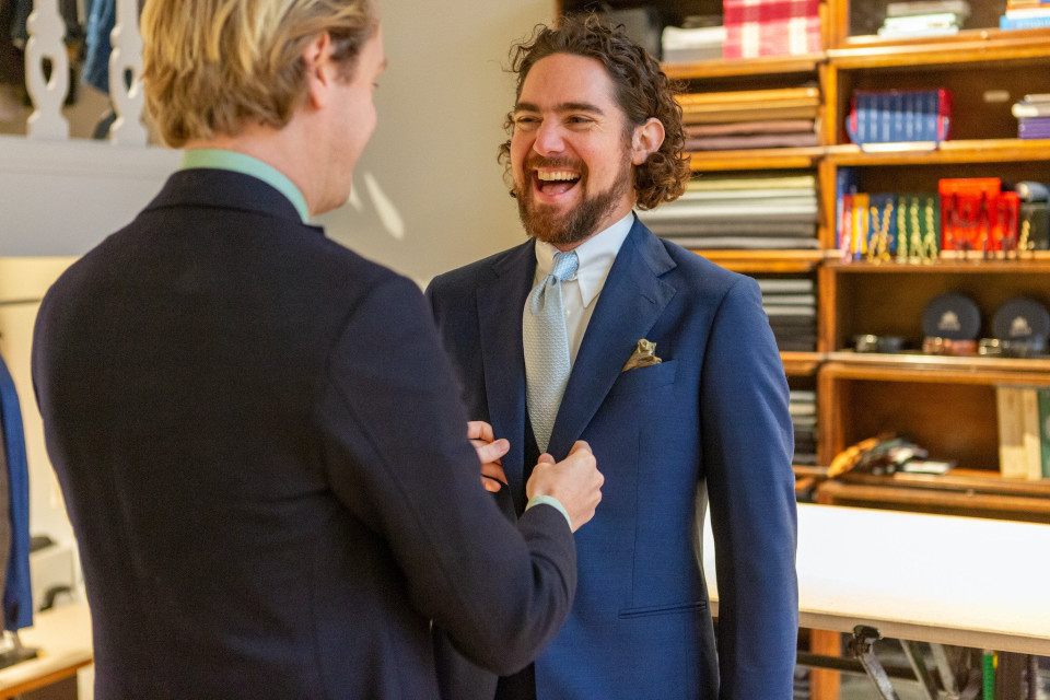 twee mannen in pakken die samen lachen