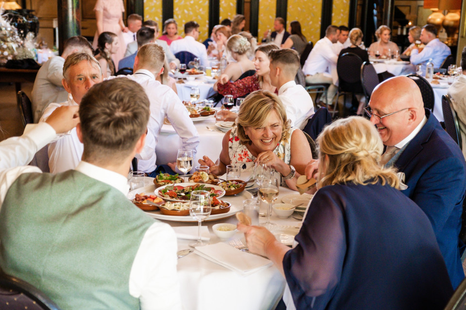 een groep mensen zit aan tafel eten