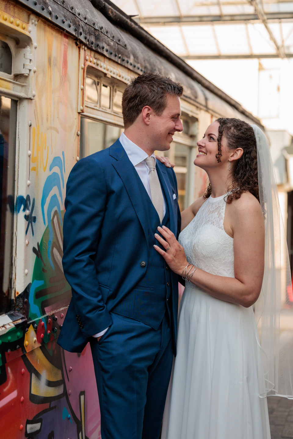 een bruid en bruidegom die voor een trein staan