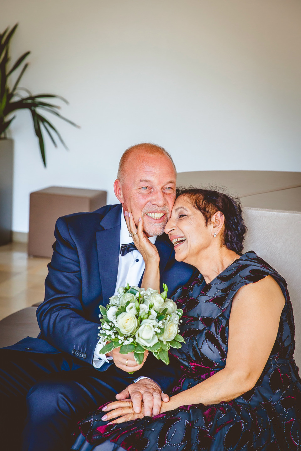een man en vrouw in formele kleding zitten op een bank