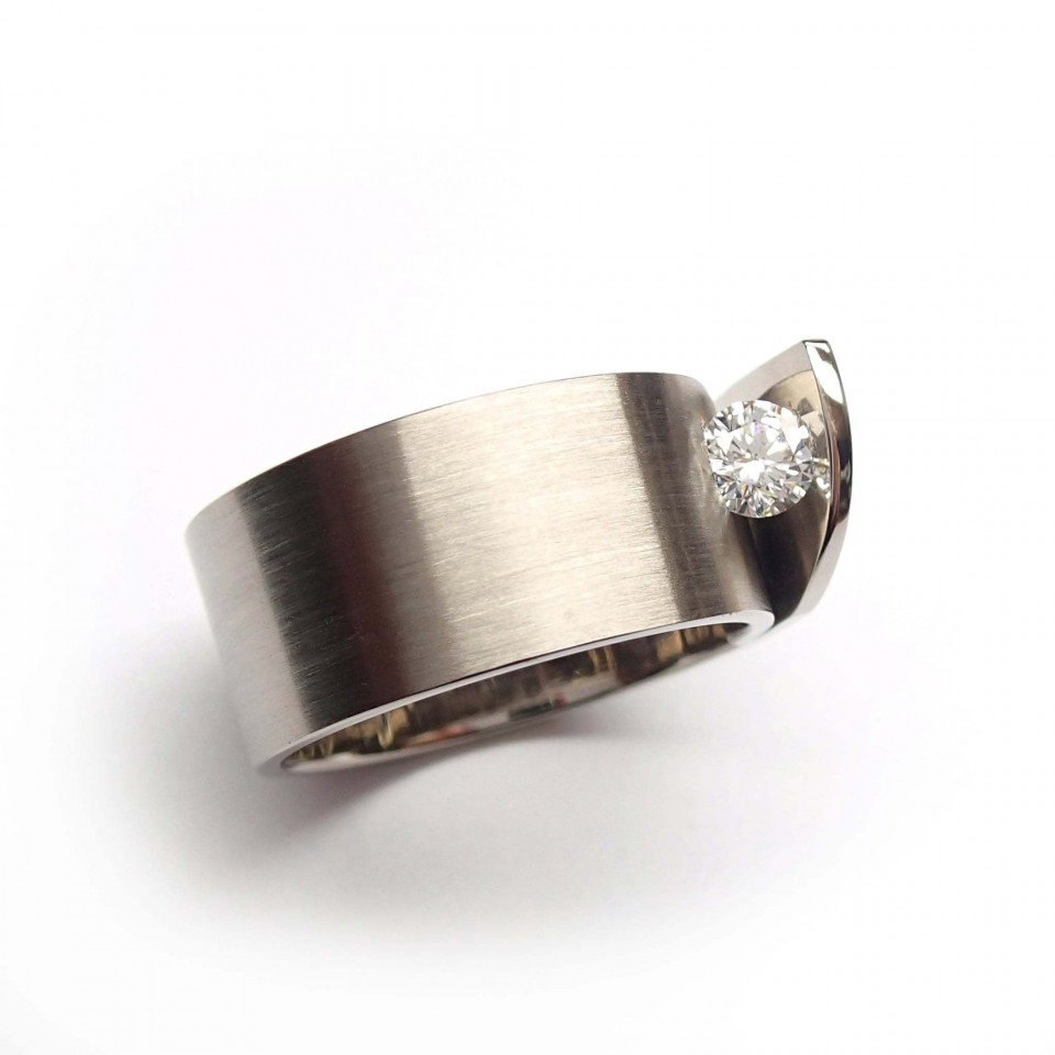 een diamanten ring met een zilveren band en een diamant