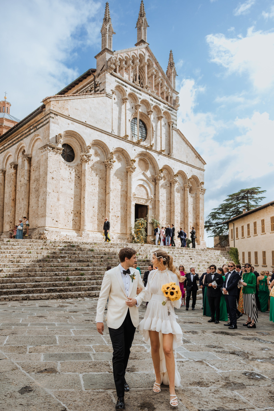 een bruidspaar loopt door de binnenplaats van een Italiaanse kerk