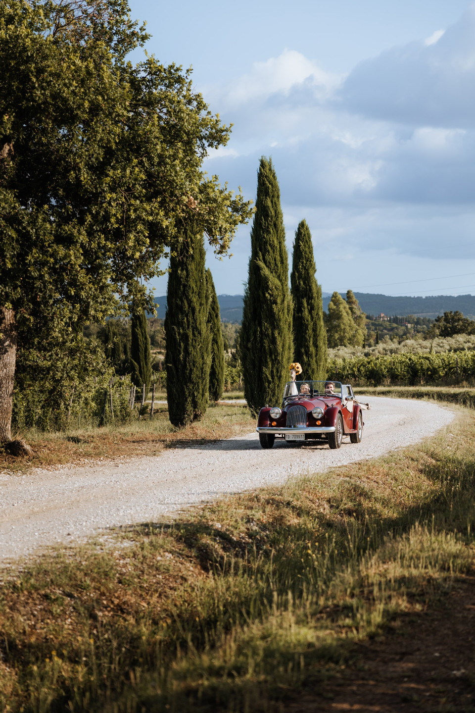 een vintage auto rijdt over een landweg