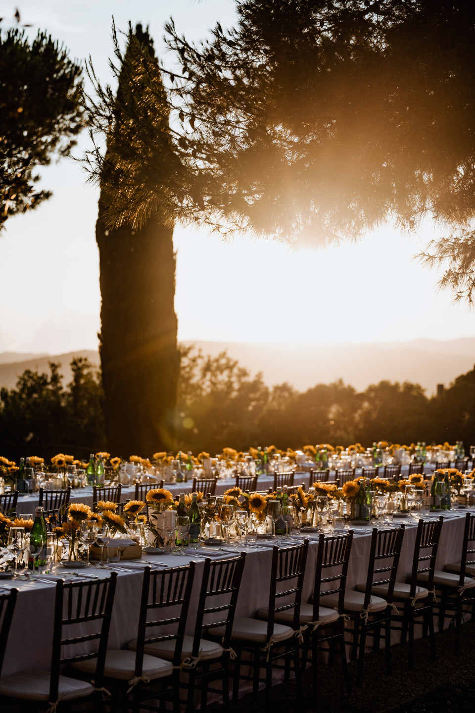 een buitenbruiloftsreceptie met tafels opgezet in de zon