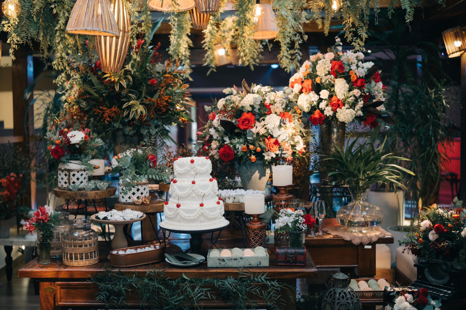 een bruidstaart wordt tentoongesteld op een tafel met bloemen