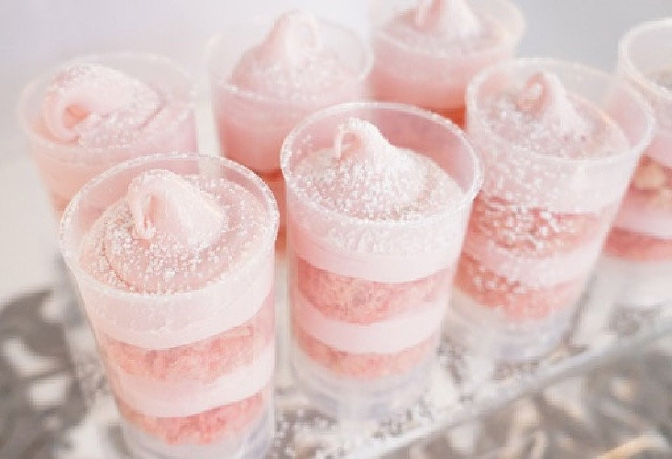 roze dessertbekers op een dienblad met poedersuiker