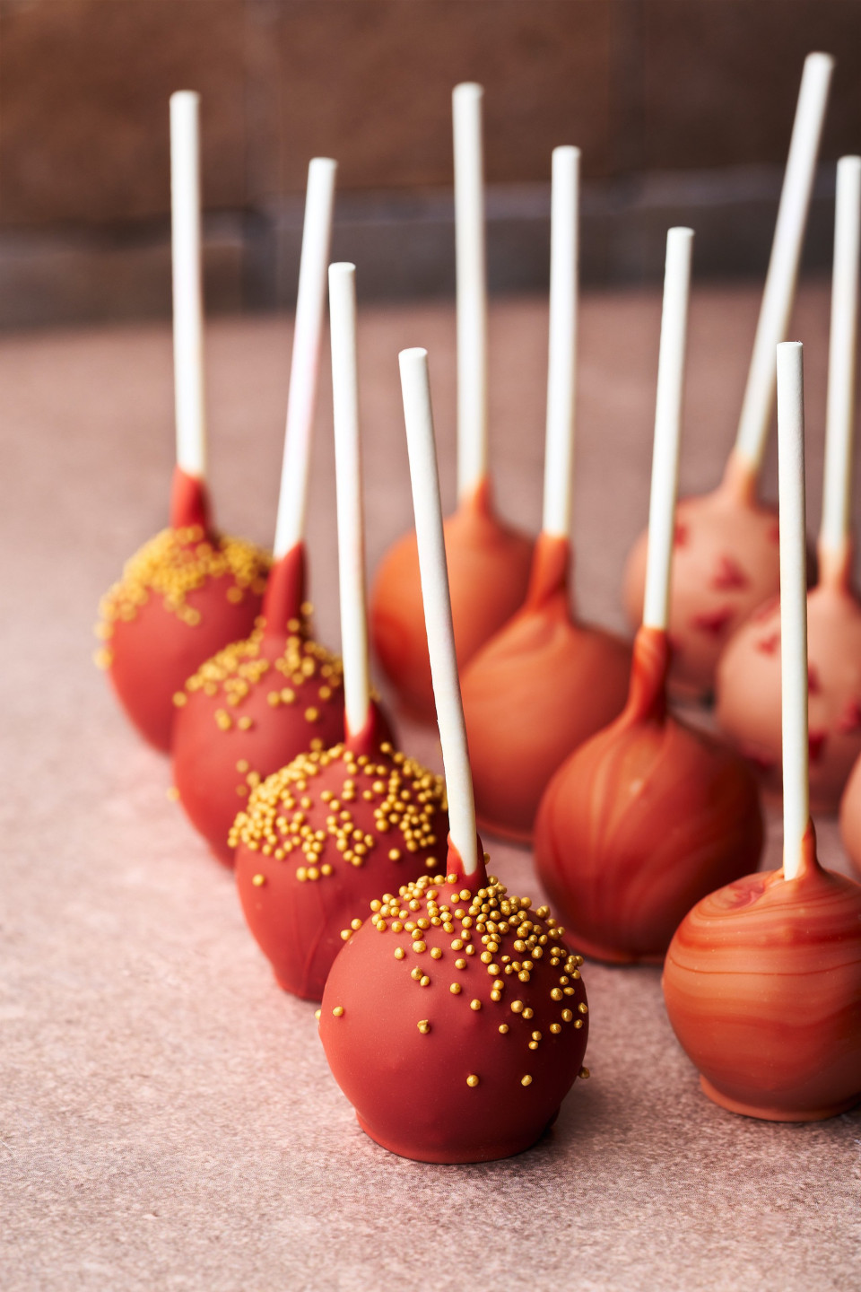 een rij cake pops met witte stokjes