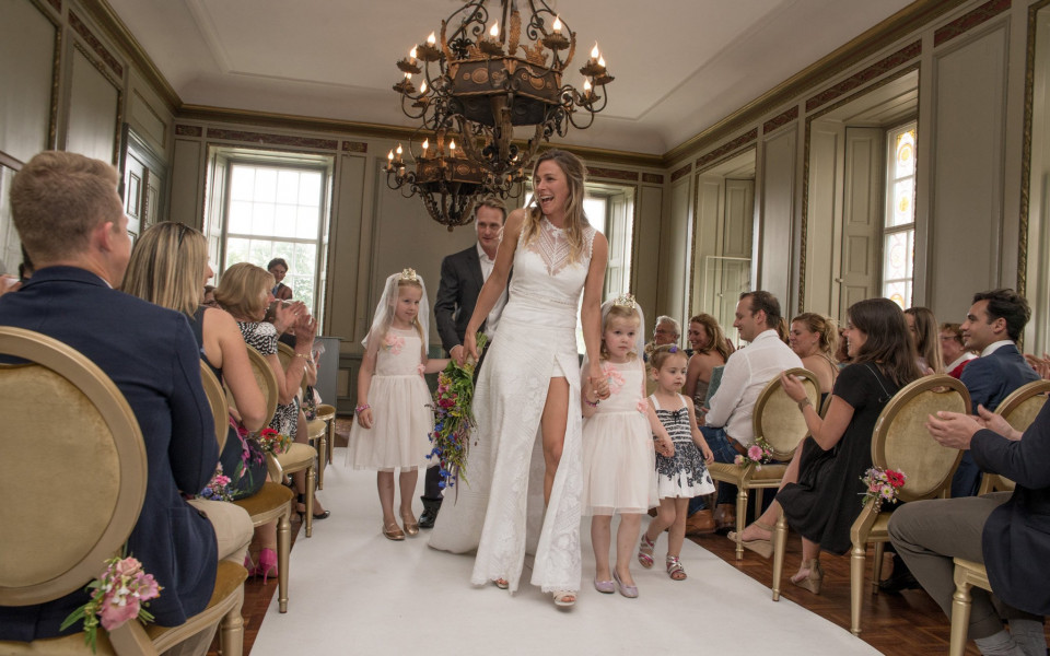 een bruid en bruidegom lopen het gangpad af bij een bruiloft