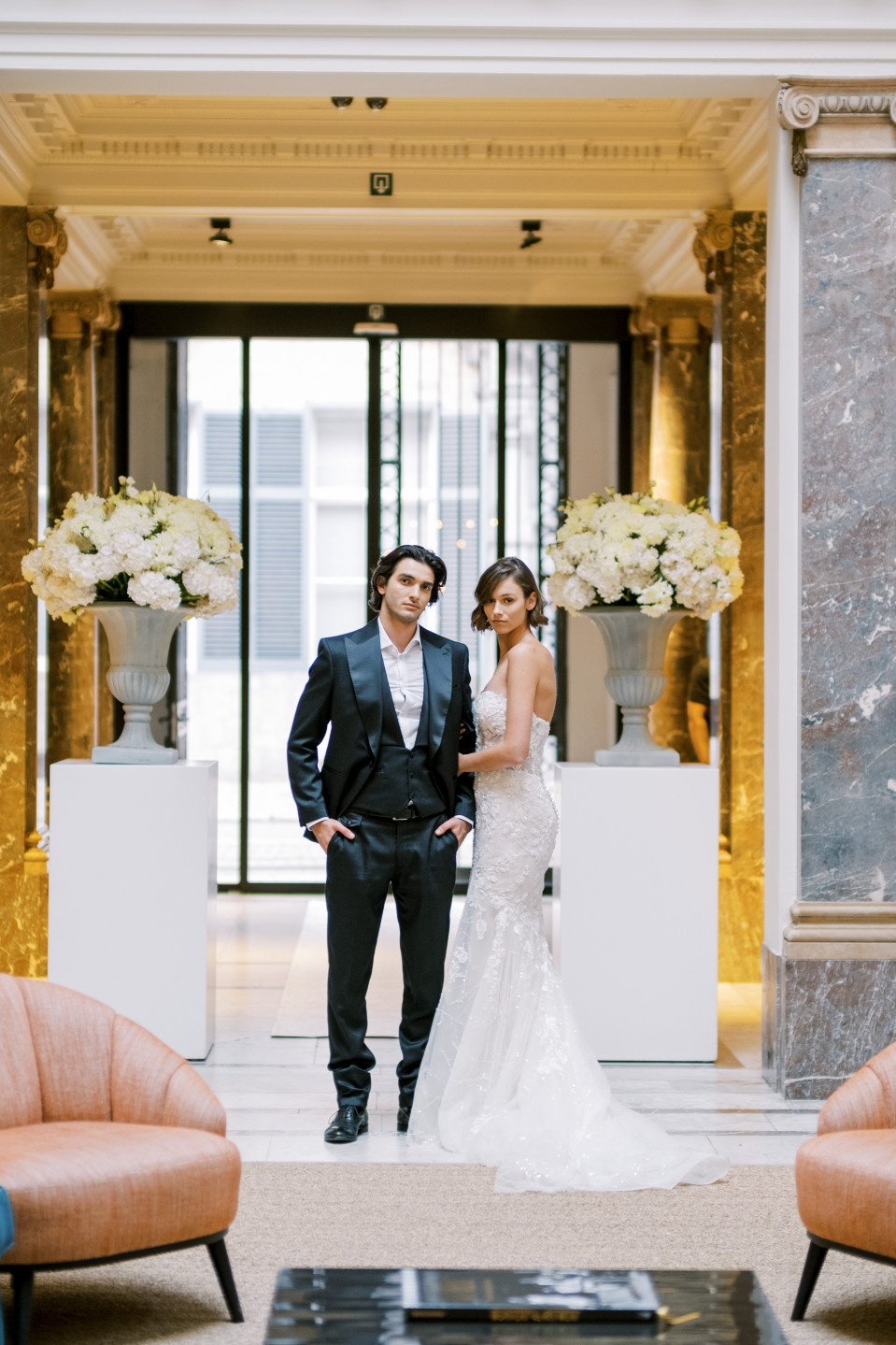 een bruid en bruidegom staan voor een grote kroonluchter