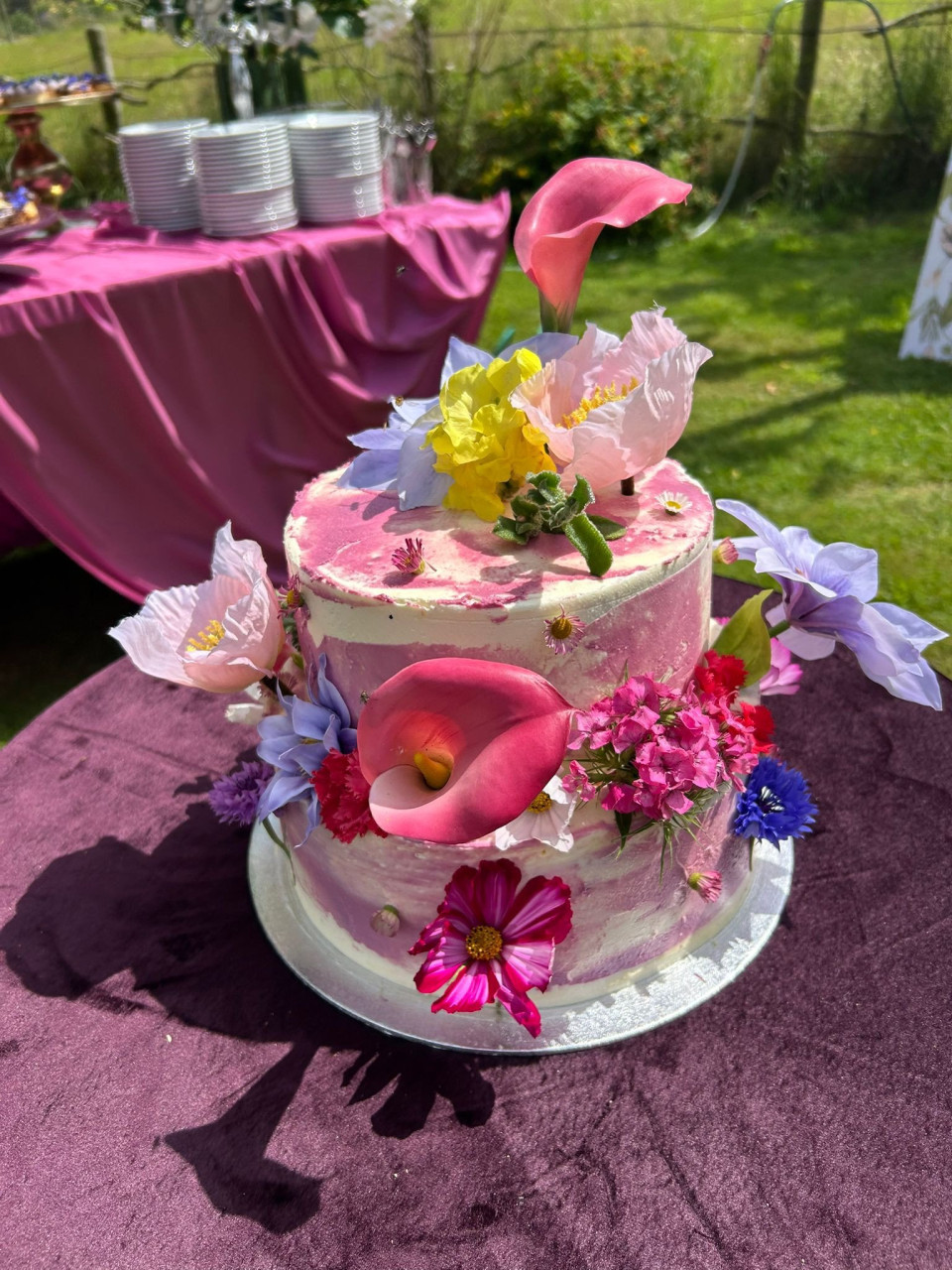 een close-up van een bruidstaart met bloemen erop