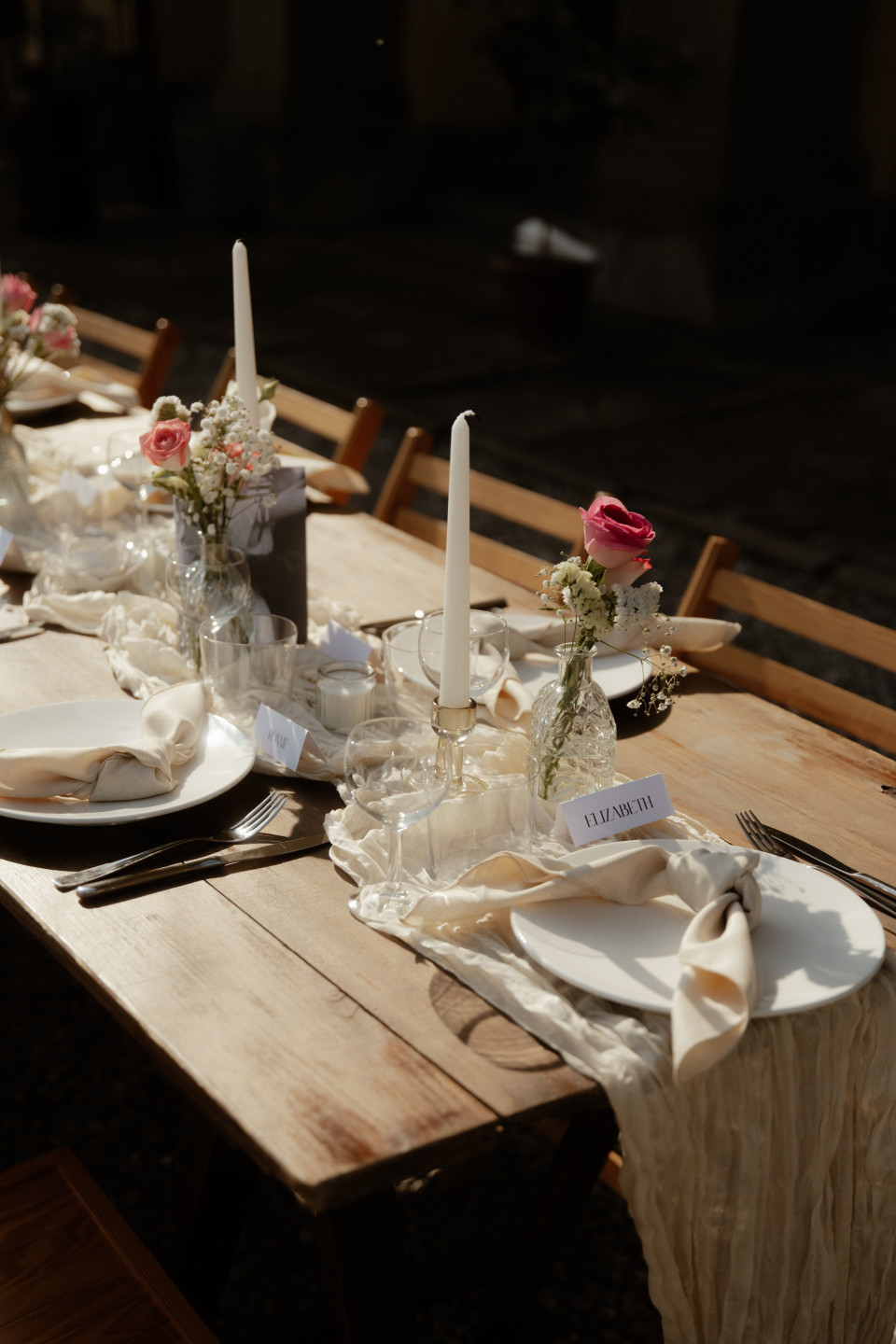 een lange tafel gedekt met witte borden en bestek