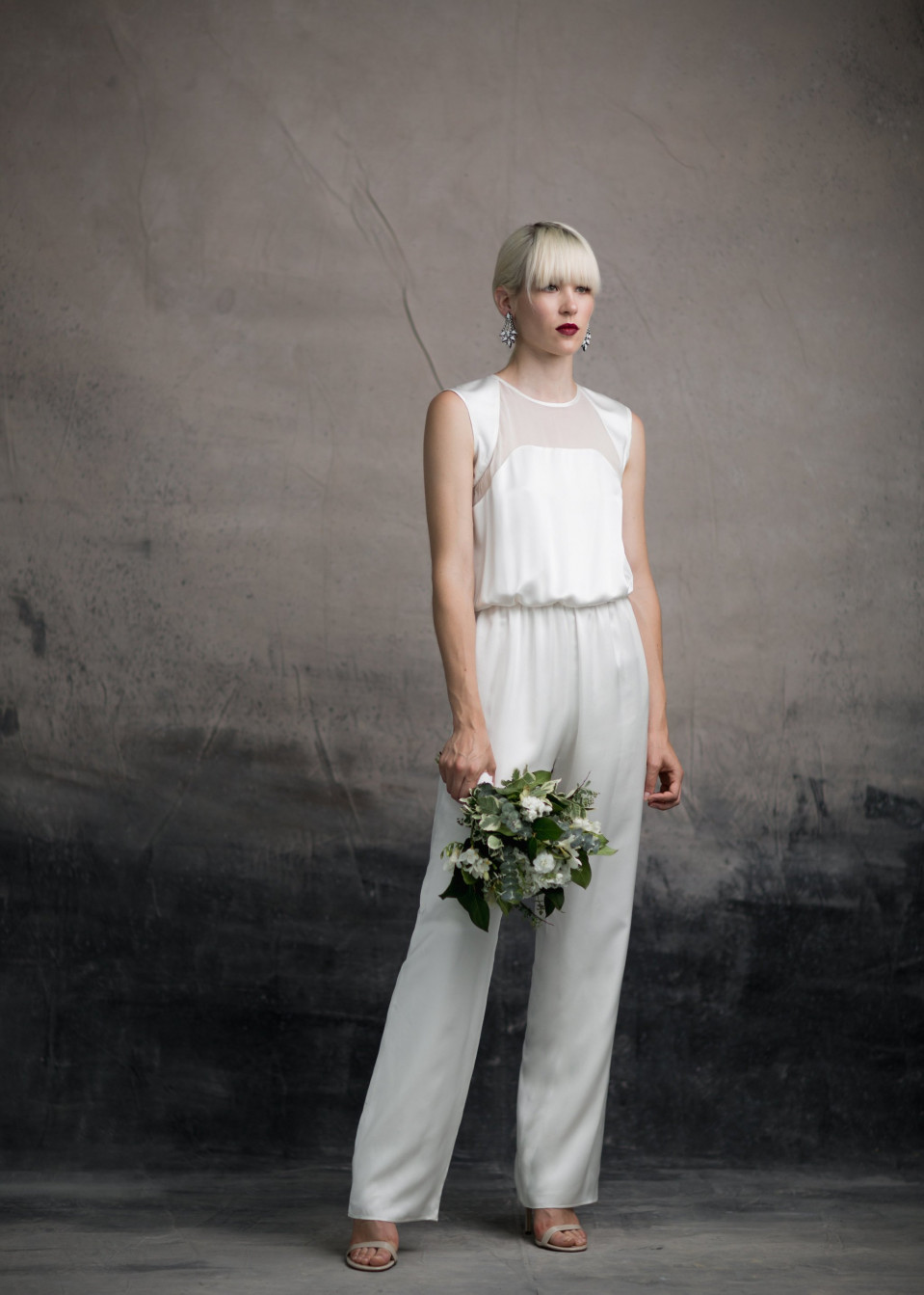 een vrouw in een wit jumpsuit en witte bloemen