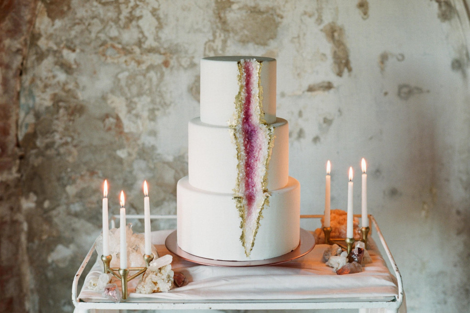 een trouwtaart met een paars en wit ontwerp erop