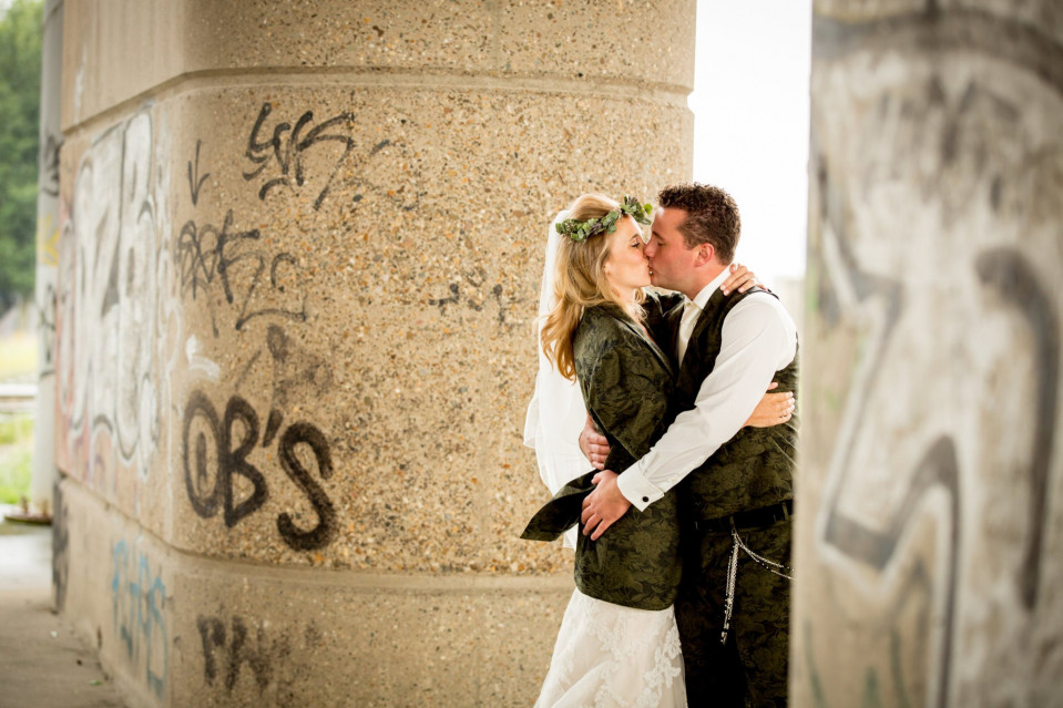 een bruid en bruidegom kussen voor graffiti bedekte pilaren