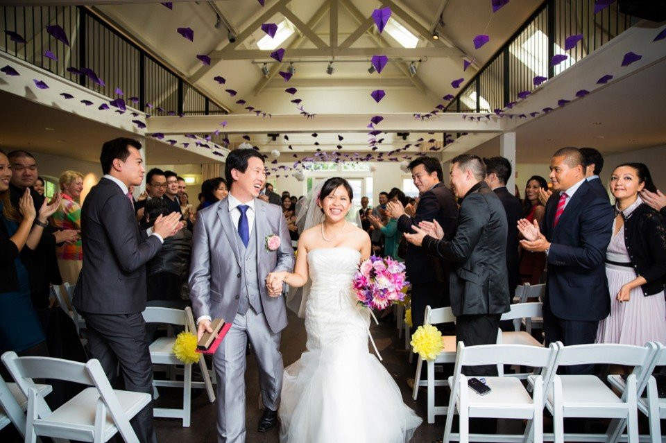 een bruid en bruidegom lopen het gangpad af op hun bruiloft