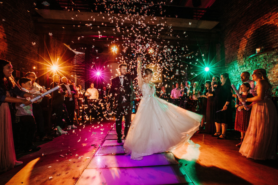 een bruid en bruidegom lopen door confetti op hun bruiloftsreceptie