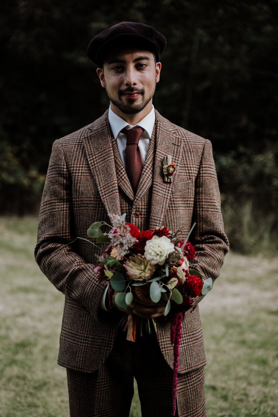 een man in een pak die een boeket vasthoudt