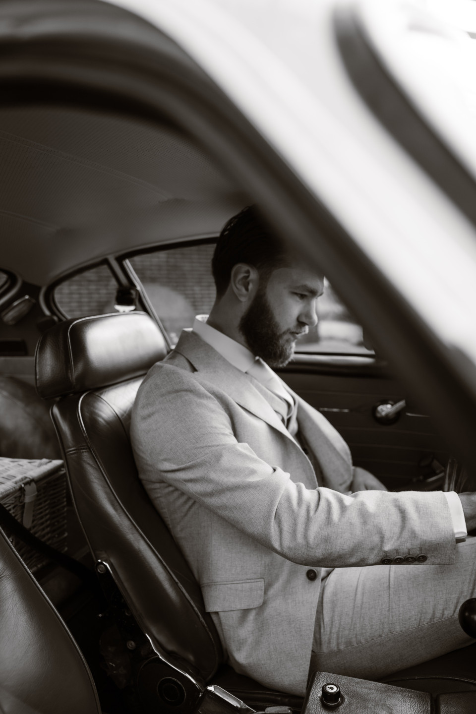 een zwart-wit foto van een man die in een auto zit