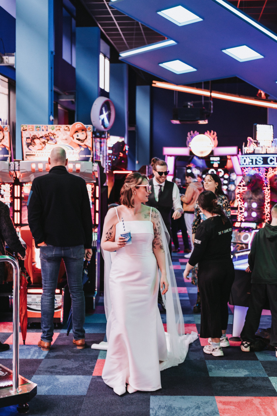 een vrouw in een trouwjurk die voor een speelautomaat staat