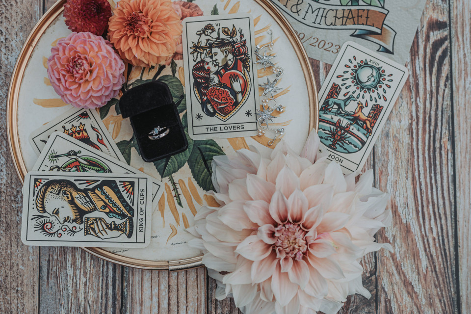 een bloem, een kaart en een ring op een houten tafel