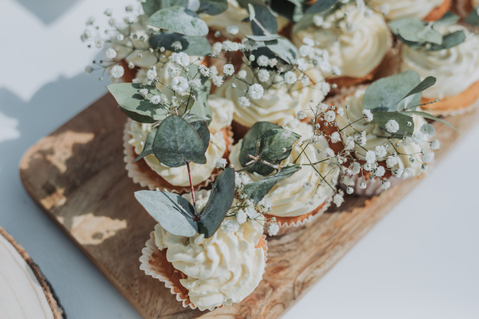 cupcakes met witte glazuur en groen op een houten dienblad
