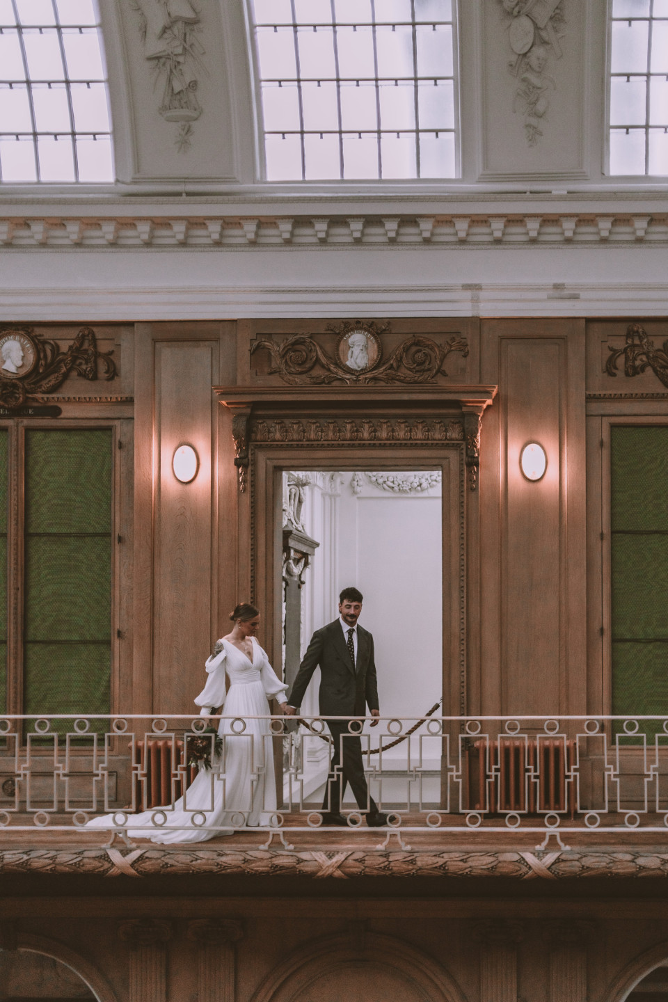 een bruid en bruidegom staan op het balkon van een gebouw