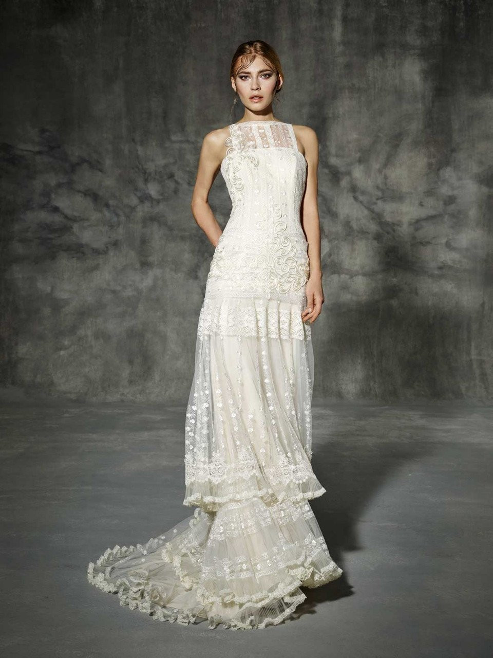 de trouwjurk is gemaakt van kant en heeft een hoge halslijn