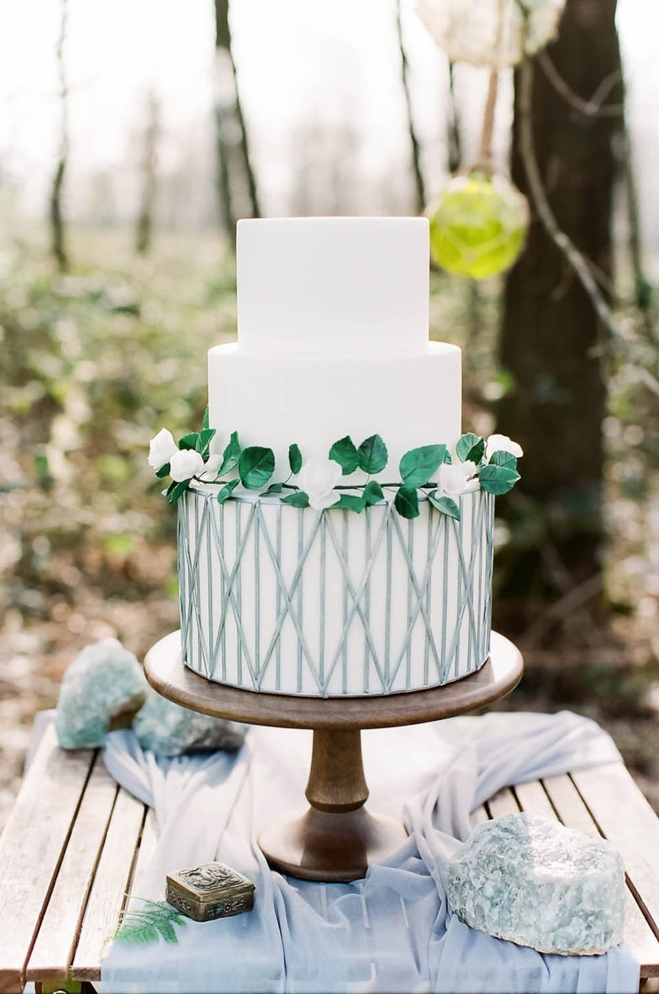 een bruiloftstaart met groenery erop