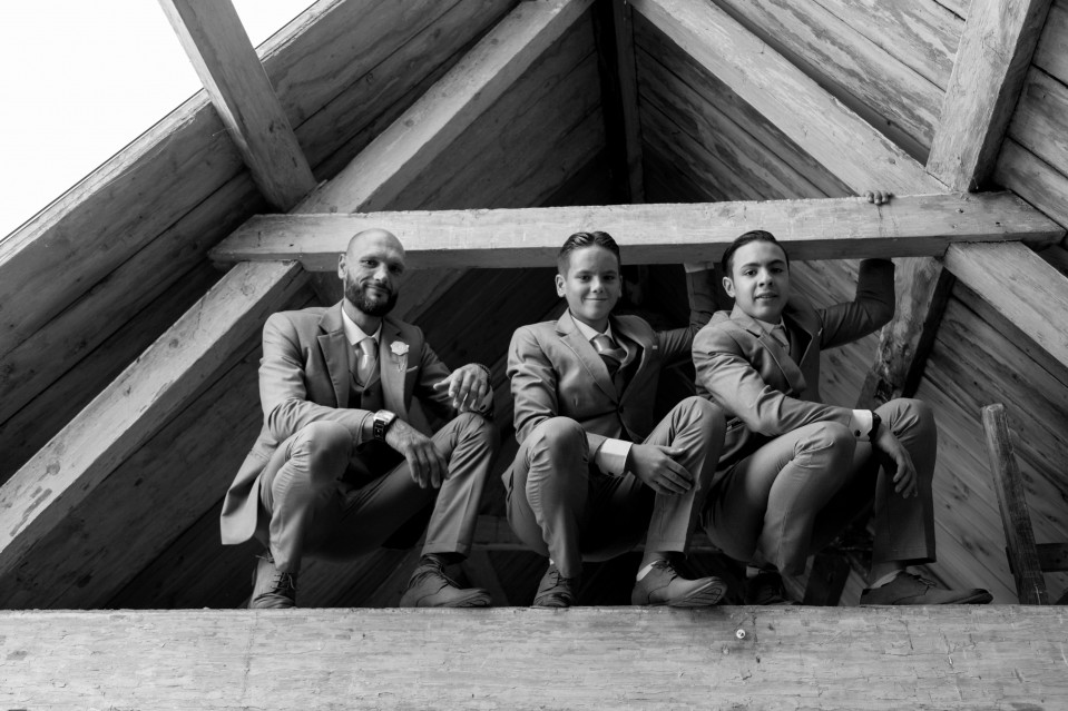 drie mannen in pakken die op het dak van een gebouw zitten