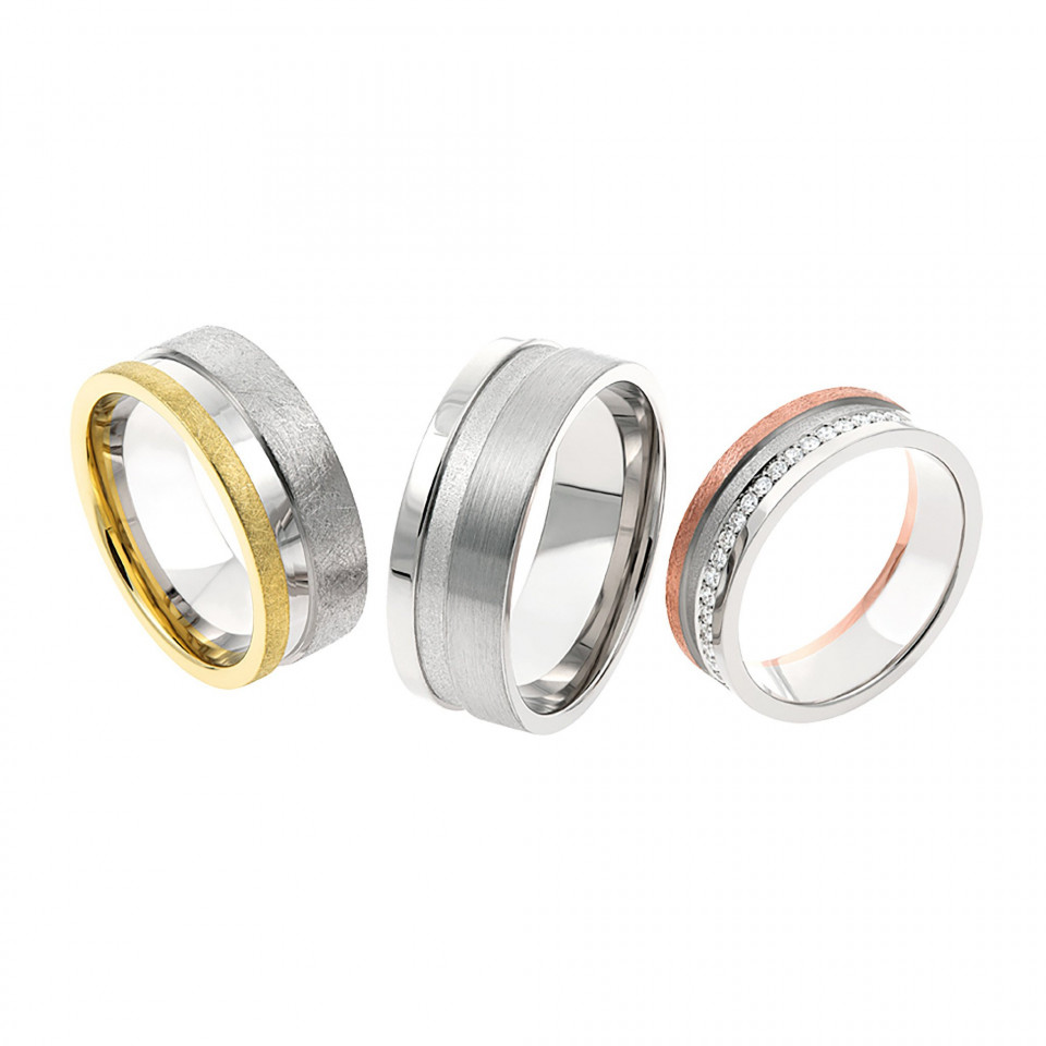 drie verschillend gekleurde trouwringen op een witte achtergrond