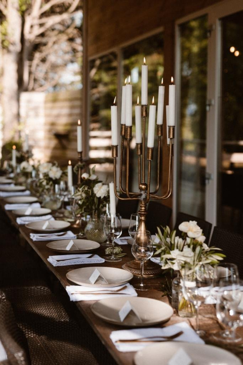 een lange tafel met kaarsen en tafelopstellingen