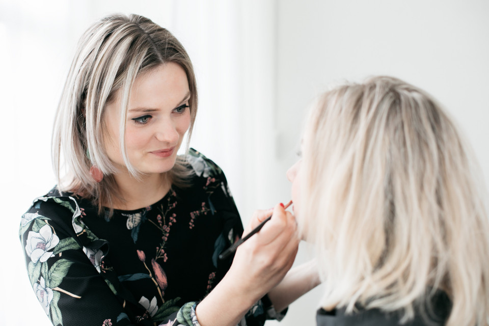 een vrouw krijgt haar make-up gedaan door een andere vrouw