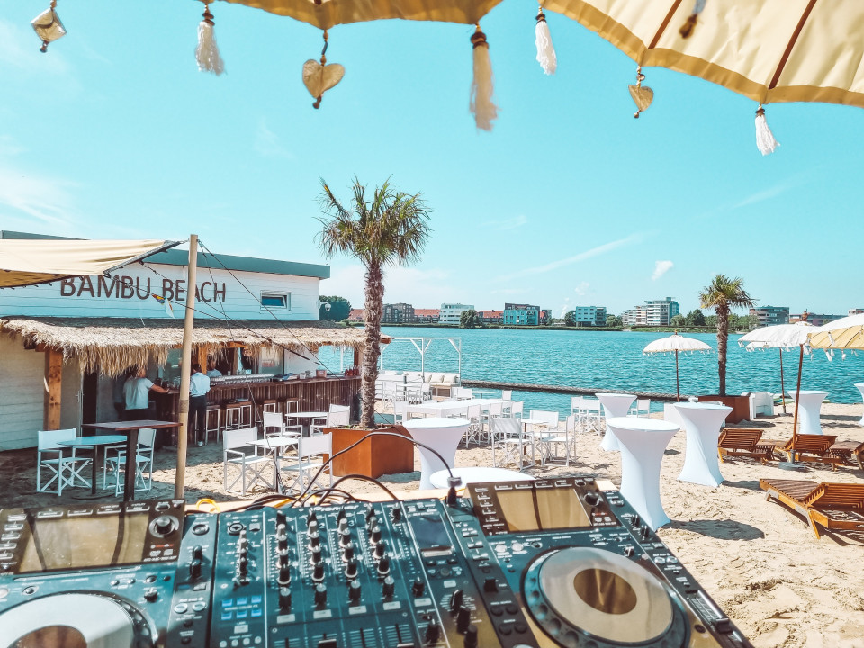 dj-apparatuur op het strand bij een watermassa