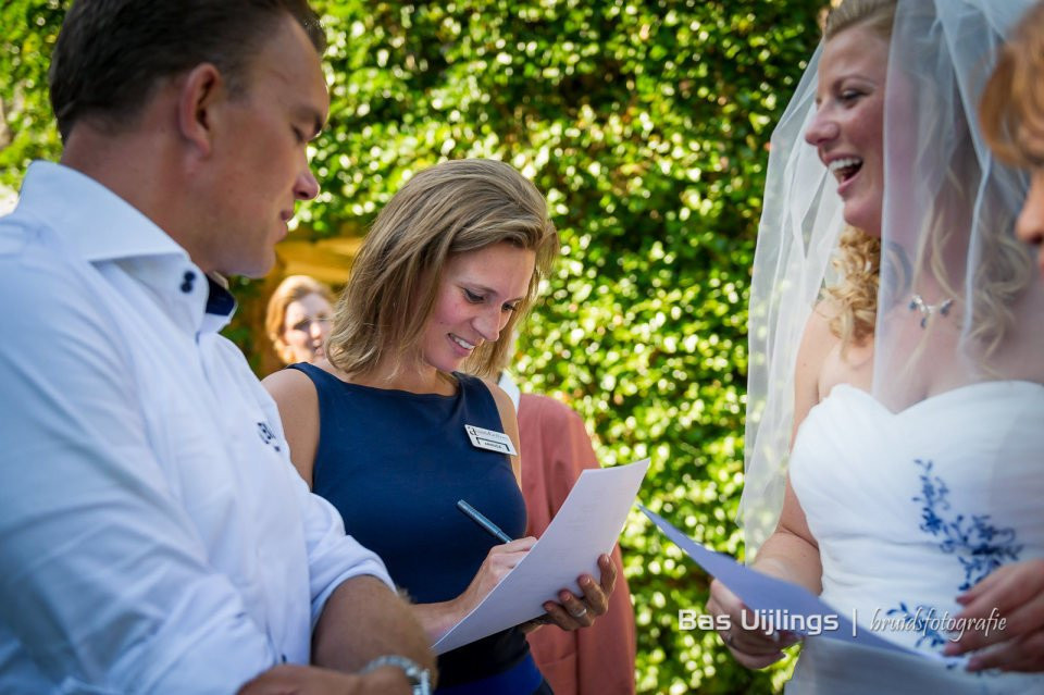 een bruid en bruidegom lachen terwijl ze hun trouwgeloften ondertekenen