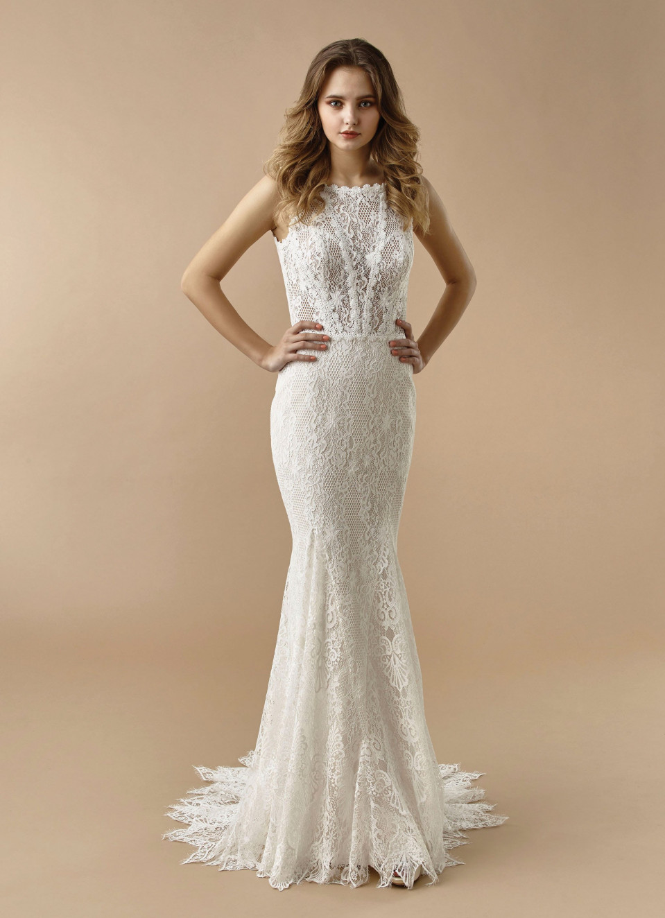 de trouwjurk is gemaakt van kant en heeft een open rug