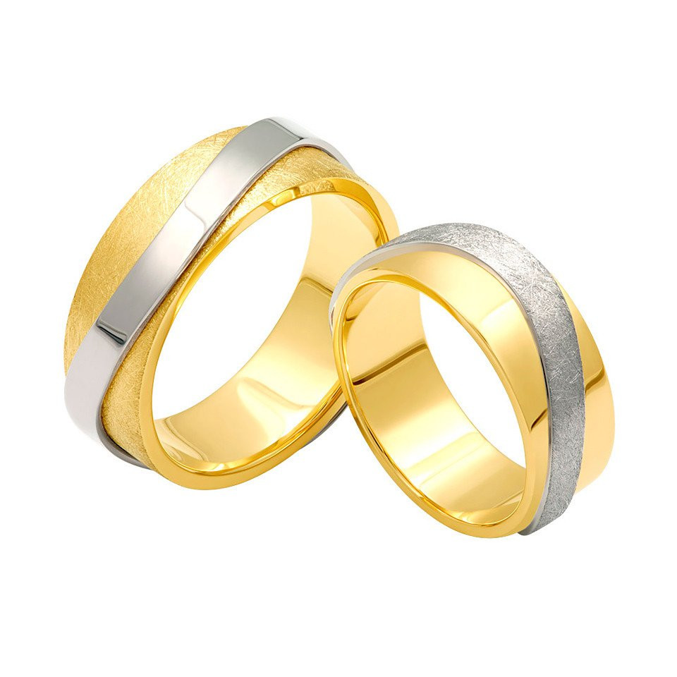 twee gouden en zilveren trouwringen op een witte achtergrond