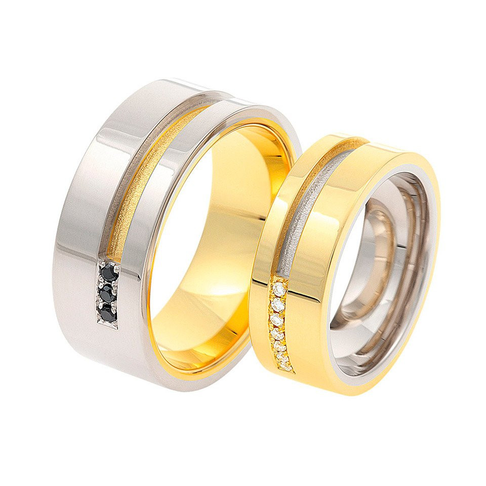 twee trouwringen van geel goud en zwarte diamanten