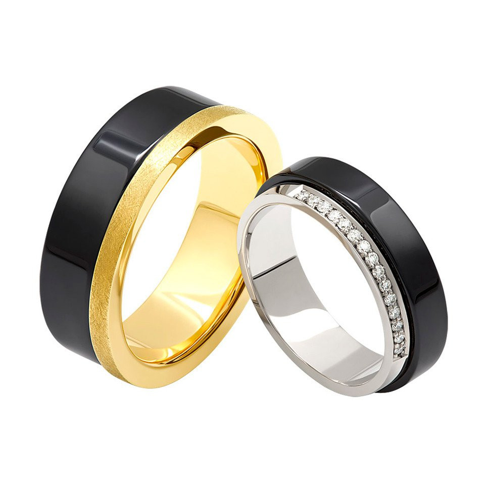 twee trouwringen met zwarte en gouden banden