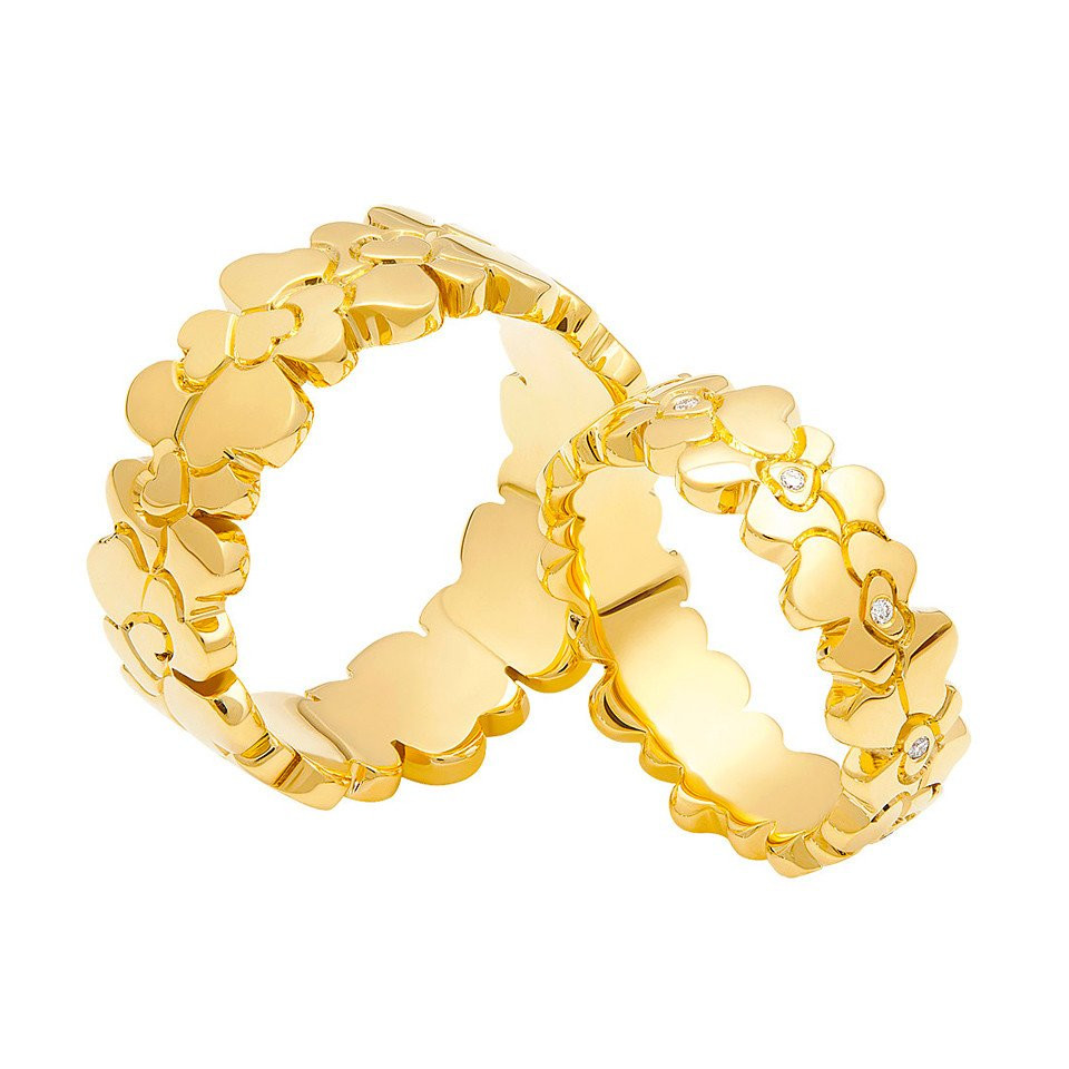 twee gouden trouwringen met harten en bloemen